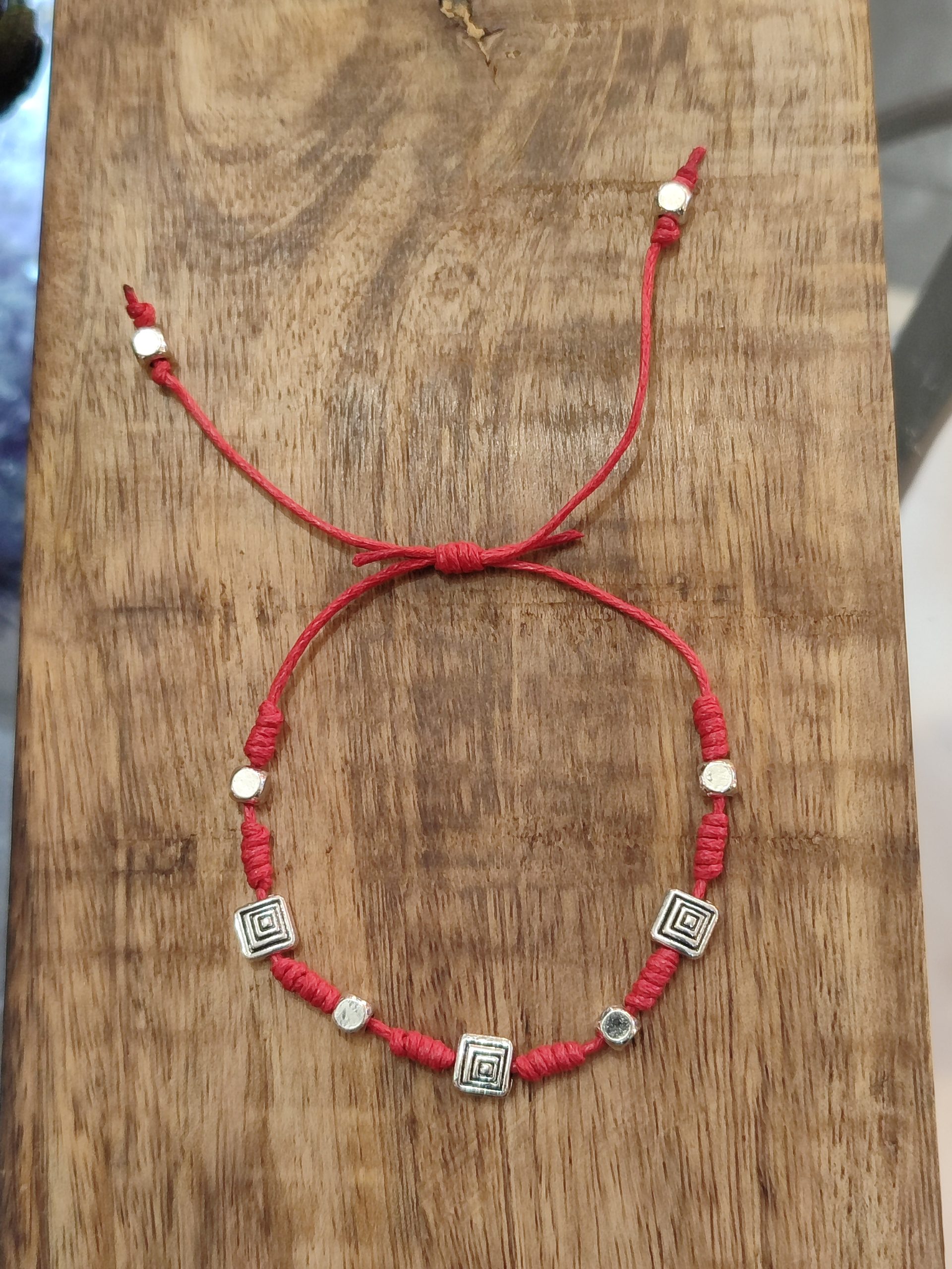 Amuleto de amor y energía vital con cordón rojo, cuentas plateadas geométricas