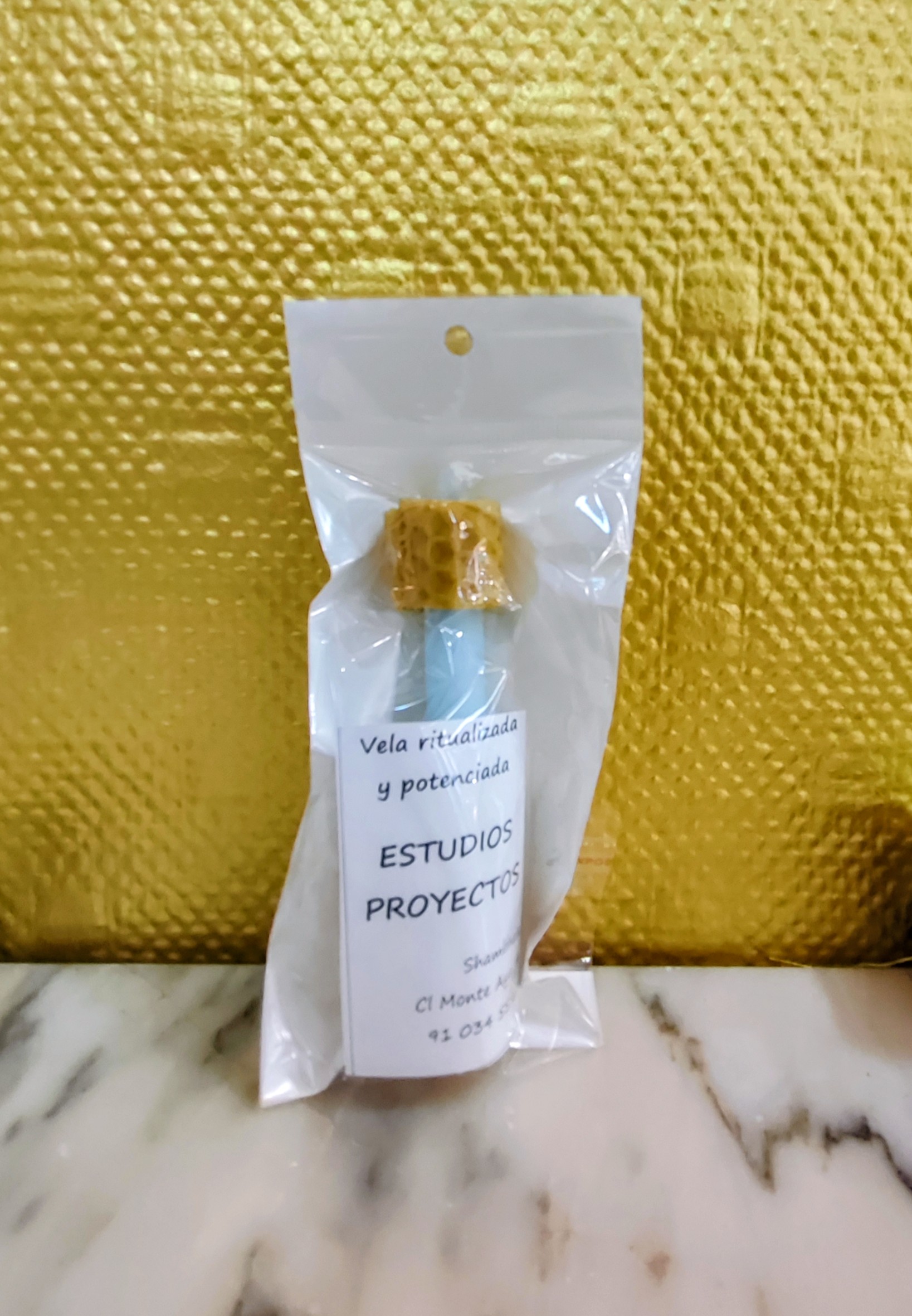 Vela artesanal ritualizada de panal de abeja (textura de miel) color azul, presentada en su envoltorio con etiqueta de Shambhala.